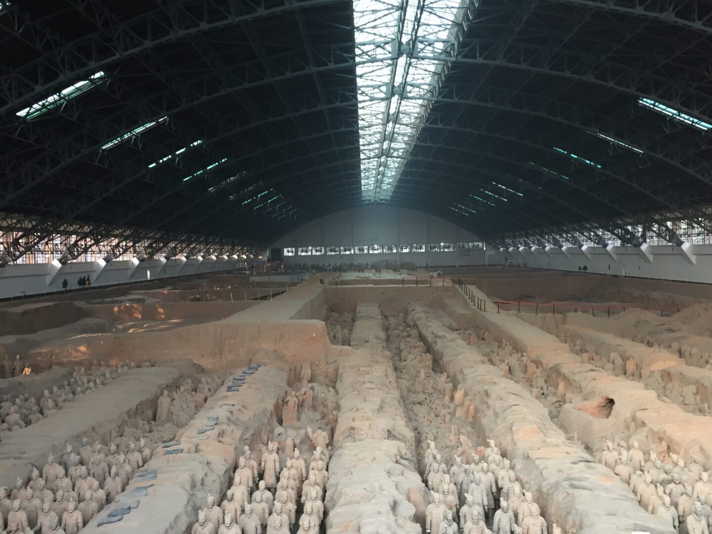 A large room with many statues of men in the middle.
